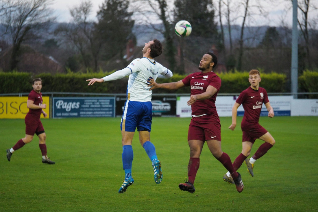 a football match showing one player heading the ball